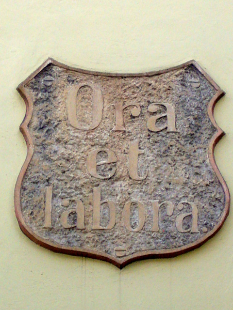 Shield showing motto *Ora et Labora*