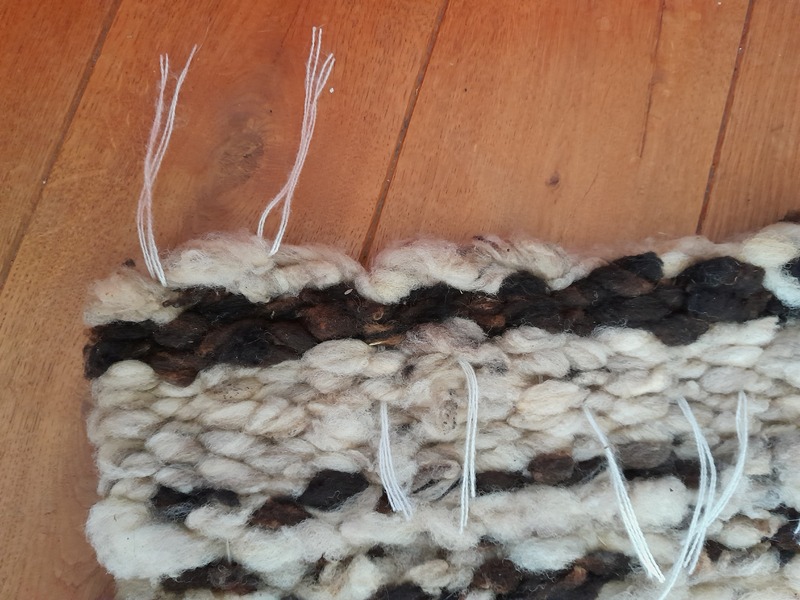 Cleaning up the warp threads at both ends of the rug.